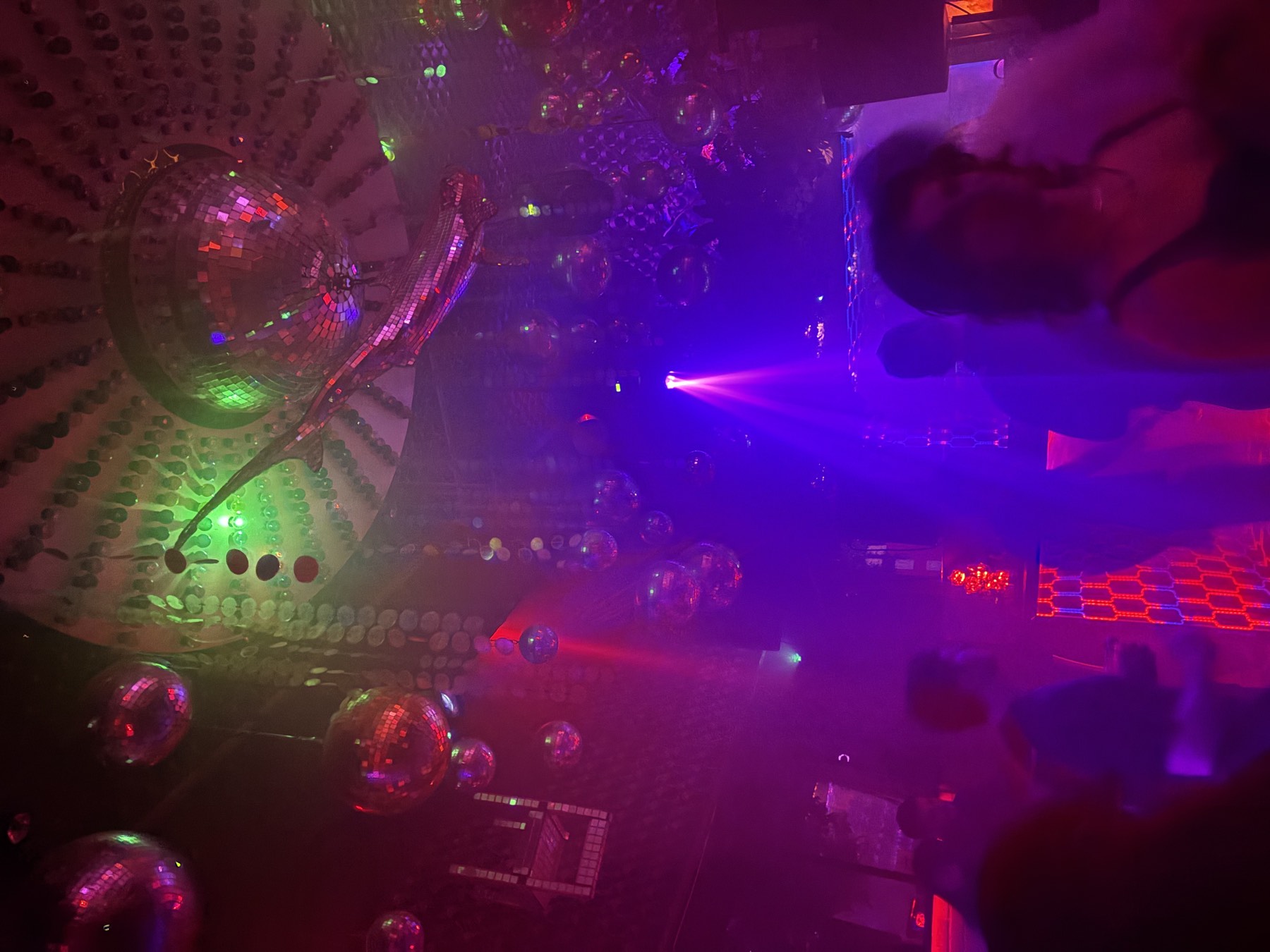 Club ceiling covered in mirror balls with beams cutting through